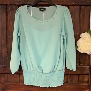 A beautiful pastel green blouse with gold detail.